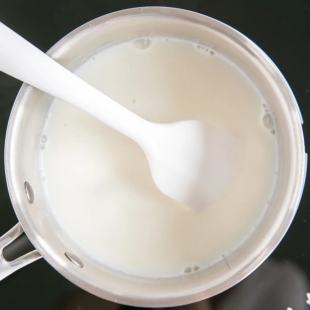 Milk and vanilla in a pot on the stove.