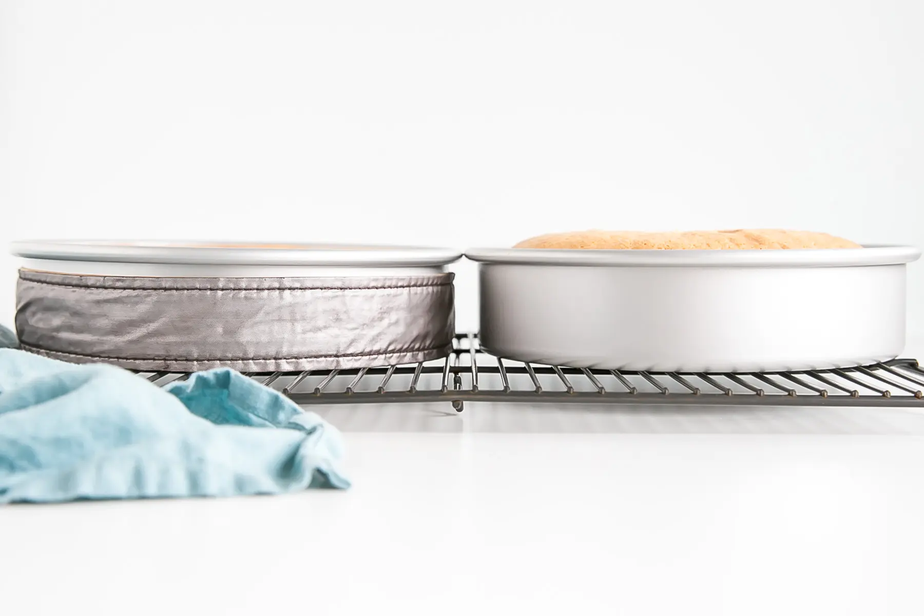 Tow cake pans side by side, one with an evenbake strip on it.