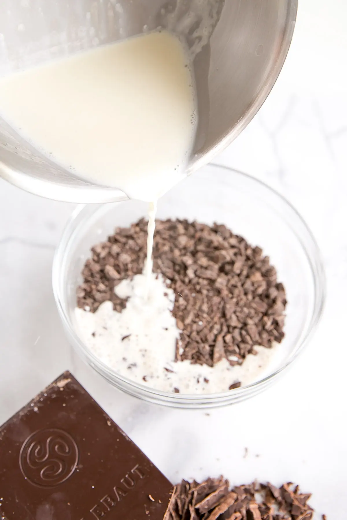 Pouring the heated cream from the pot into the bowl of chocolate.