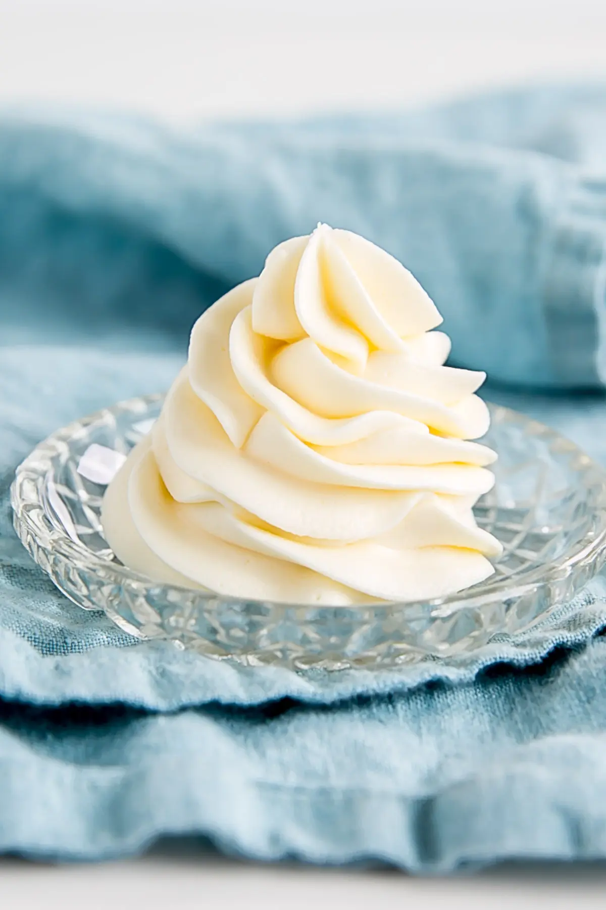 Ermine-Frosting auf einem kleinen Teller ein einem blauen Geschirrtuch.