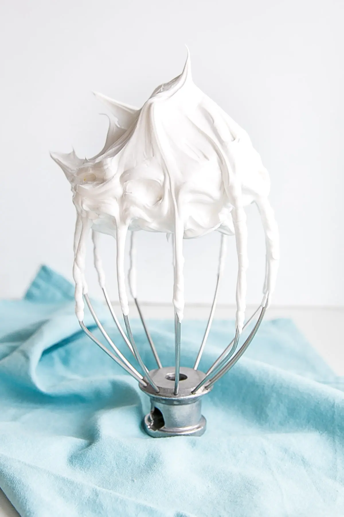 7 minute frosting shown on a stand mixer whisk. 