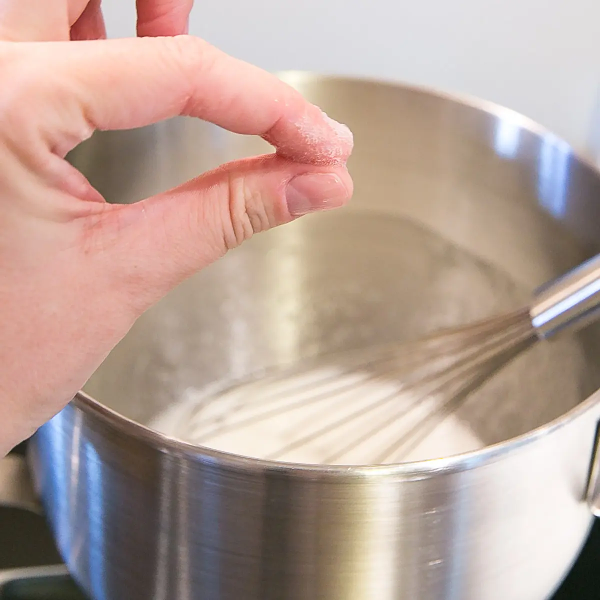 Testing the meringue for graininess by rubbing in between two fingers.