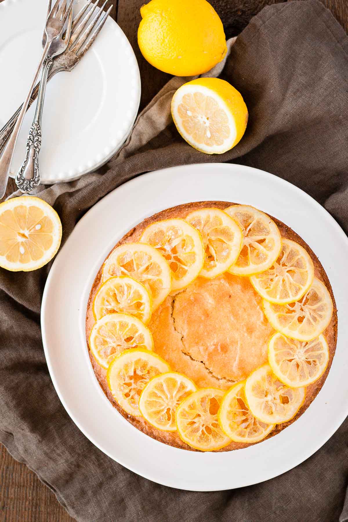 Vue aérienne du gâteau sur une assiette blanche avec des citrons coupés à côté.