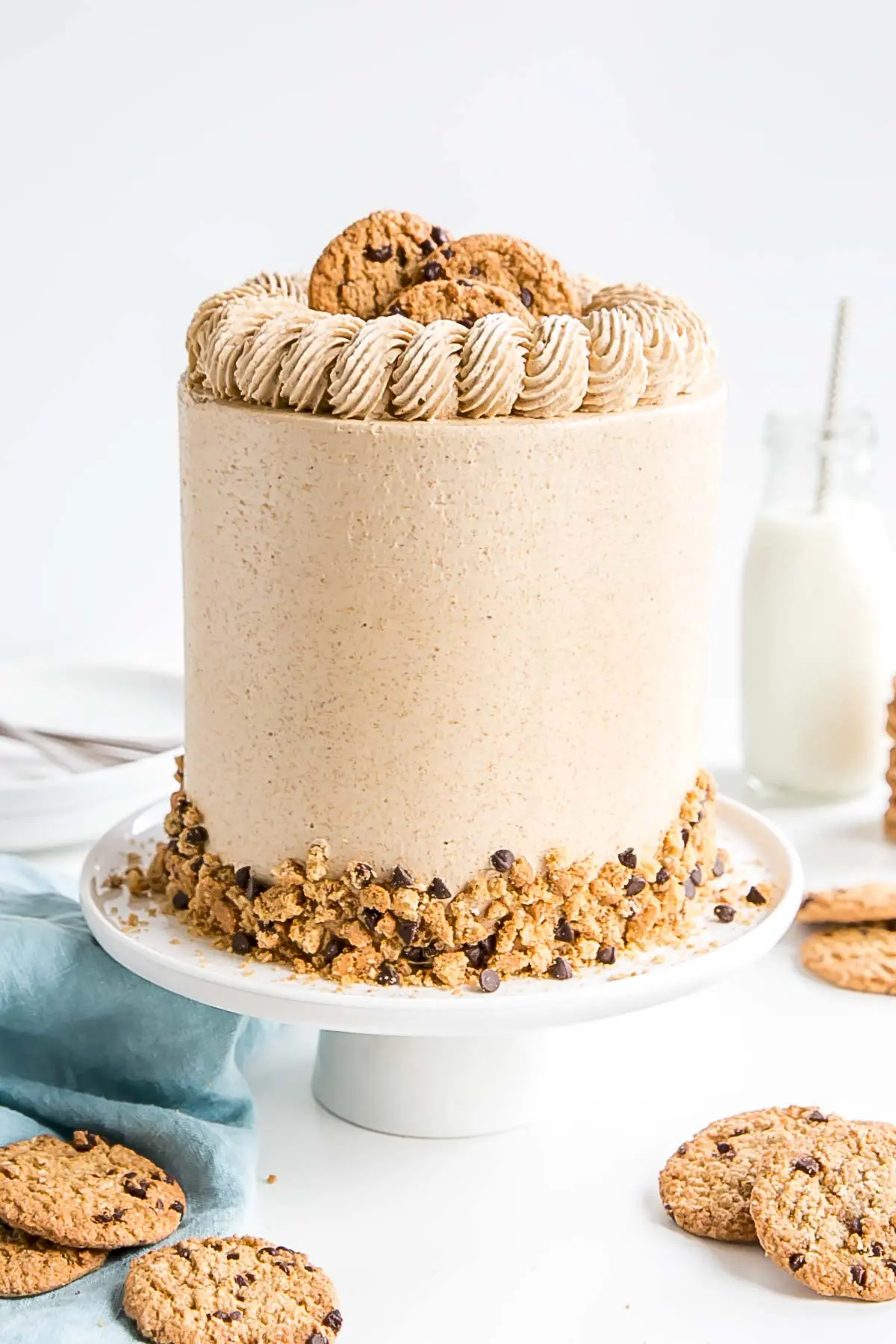 Cake on a white cake stand with a blue cloth in the background.. 